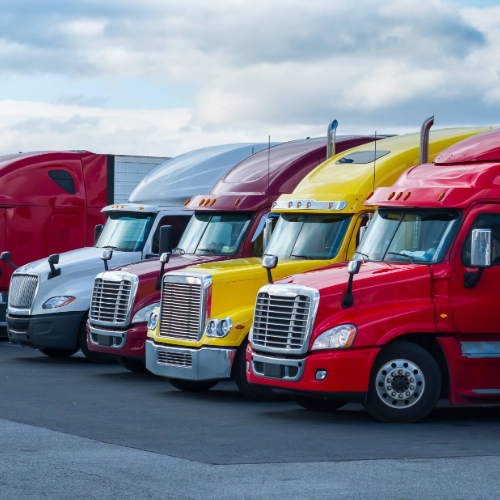 a row of trucks in red, yellow and white parked in a lot